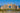 Luxury hotel complex with a large pool and beach area on a clear day.